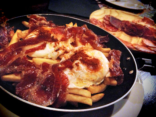 Porção de batatas fritas, linguiça e ovos estrelados, no La Taverna de Barcelona