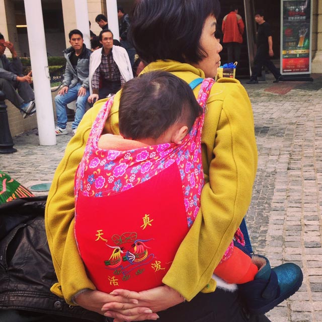 Mãe acomoda seu filho nas costas, na altura da parada Ponte 16 (via Instagram)