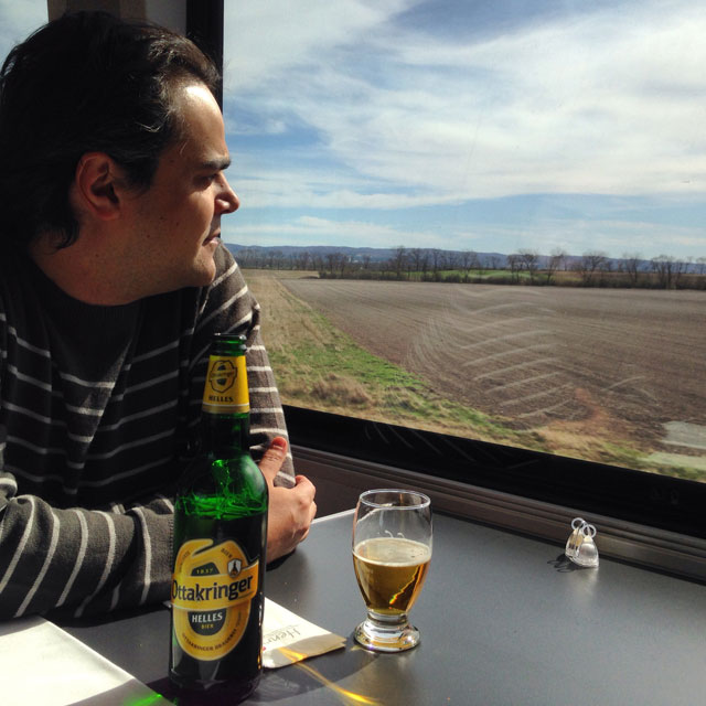 Élcio degusta uma cerveja no trem de Viena a Budapeste (via Instagram)
