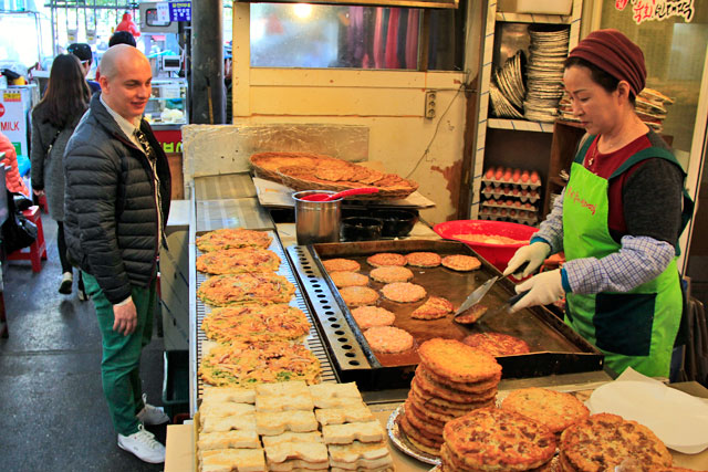 Aguardo o preparo do bindaetteok, no mercado de Kwangjang