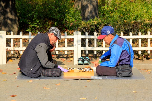 Senhores se divertem com o go, em praça ao lado do Santuário de Jongmyo
