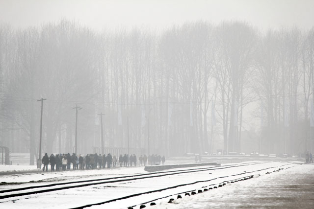 Visitantes seguem em direção às ruínas das câmaras de gás, em Auschwitz II