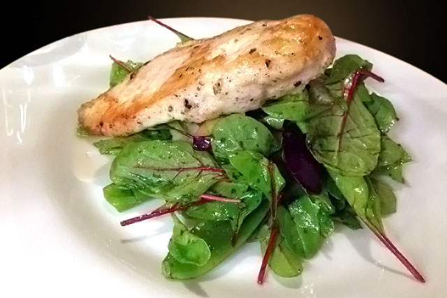 Peito de frango com ameixas e folhas de beterraba servido no Etno Baras